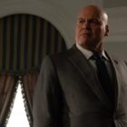 Bald man in suit near windows