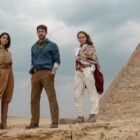 Eiza Gonzalez, John Krasinski and Natalie Portman (L-R) standing next to a pyramid in Apple TV Plus' "Fountain of Youth"