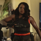Viola Davis in a bulletproof vest with a gun elbowing a man in G20