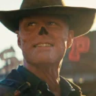 Cowboy with facial prosthetic in bright setting.