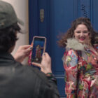 felix takes a photo of jess while she poses by the notting hill door in too much