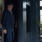A man wearing a baseball cap standing in a room in Your Friends &amp; Neighbors