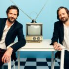 Ross Duffer and Matt Duffer, creators and producers of Stranger Things in a room with a CRT TV