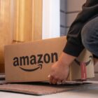 Someone putting an Amazon box on a doorstep.