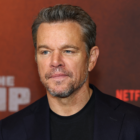 A man with short hair and a beard, wearing a dark suit, stands in front of a backdrop with "The Rip" and "Netflix" logos.