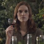 Fleur Geffrier holds a glass of wine up to her face in Drops of God season 2