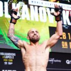 Alexander Volkanovski raises his arms to the air in the final press conference before fighting Diego Lopes in their rematch for the UFC Featherweight Championship.