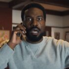 Simon Williams looking shocked as he listens to someone during a mobile phone call in Marvel's Wonder Man
