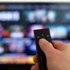 A person holding a remote deciding what to stream. 