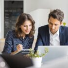 Two investors study something on a laptop.