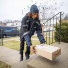 A delivery driver dropping off an Amazon package.