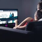 Two people watching a movie on a TV together.