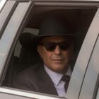 Kevin Costner in a limo with a large cowboy hat on