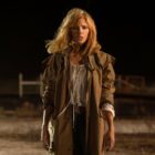 Beth Dutton stands in the middle of a dirt road