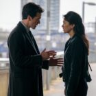 a man and woman talking on a bridge