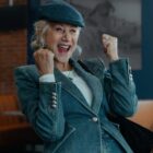 Helen Mirren smiles with and makes a triumphant gesture with her fists in the air in "MobLand" Season 2