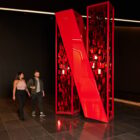 People walking by a large Netflix logo.