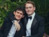 Nick and Charlie wear tuxedos and pose for a photo